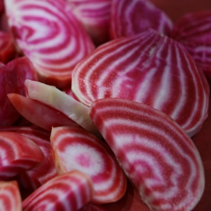 Sliced Chioggia beetroot showing pink and white concentric rings.